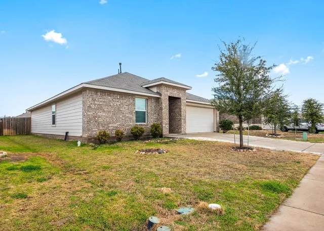 a view of a house with a yard garage and outdoor seating