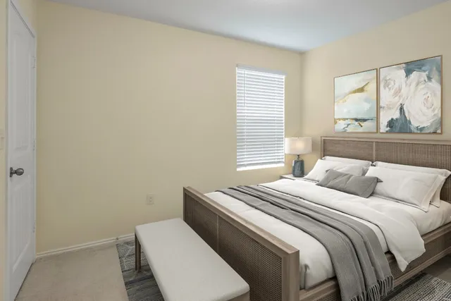 a bedroom with a bed cabinets and window