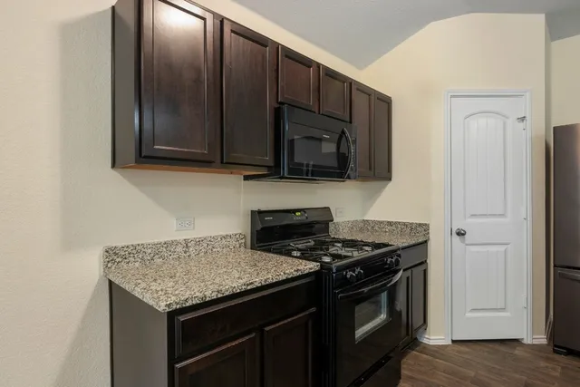 a kitchen with stainless steel appliances granite countertop a sink dishwasher and refrigerator