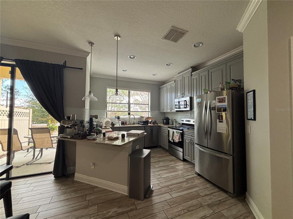9136 Fox Sparrow Road Tampa, FL 33626 - Photo 13 of 34 a kitchen with kitchen island a counter top space a sink appliances and cabinets