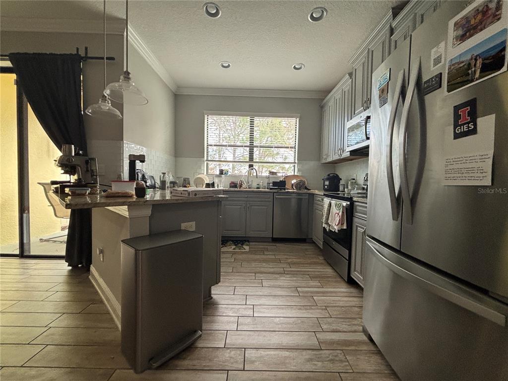9136 Fox Sparrow Road Tampa, FL 33626 - Photo 14 of 34 a kitchen with stainless steel appliances granite countertop a sink stove and refrigerator