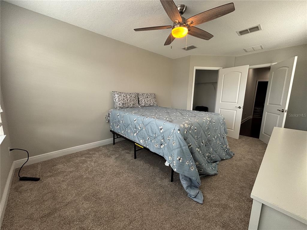 9136 Fox Sparrow Road Tampa, FL 33626 - Photo 30 of 34 a bedroom with a bed and a chandelier