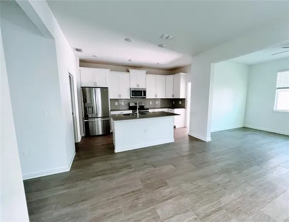 a kitchen with stainless steel appliances a refrigerator sink and microwave
