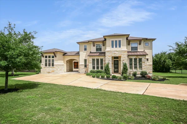 a front view of a house with yard and green space