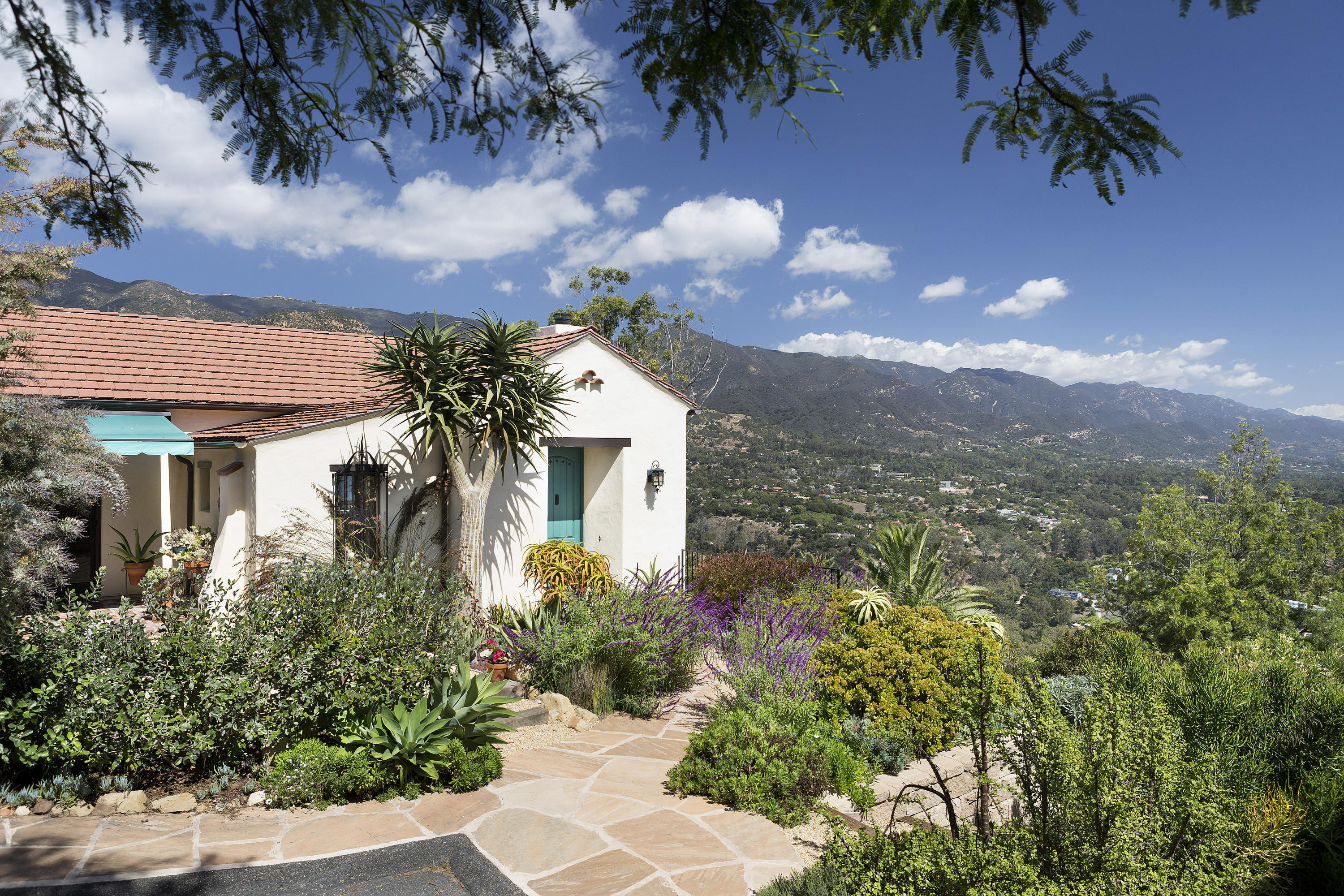 a front view of a house with a yard and mountain view