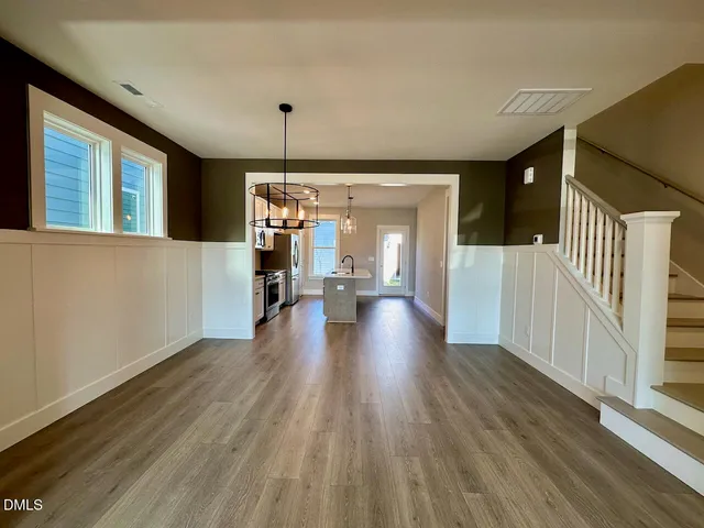 a large kitchen with kitchen island a large counter top space a sink stainless steel appliances and cabinets