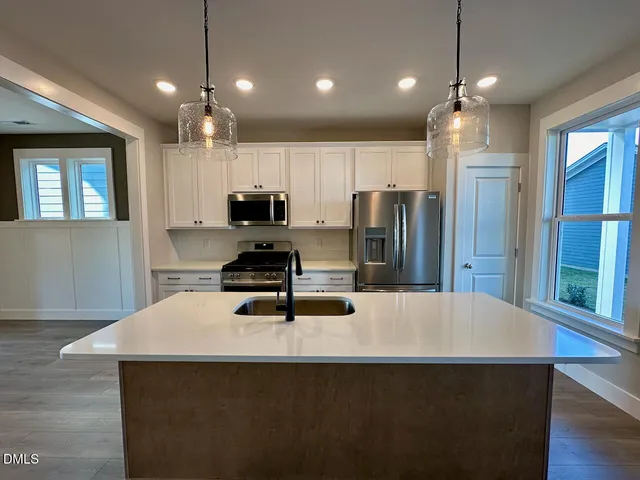 a kitchen with sink cabinets and wooden floor