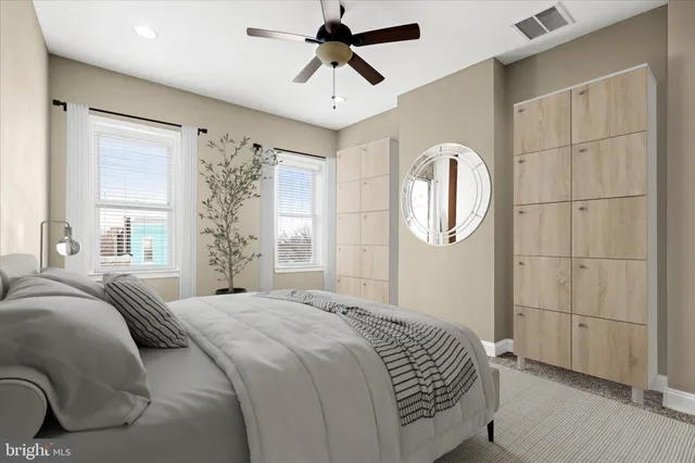 a living room with couches and kitchen view with wooden floor