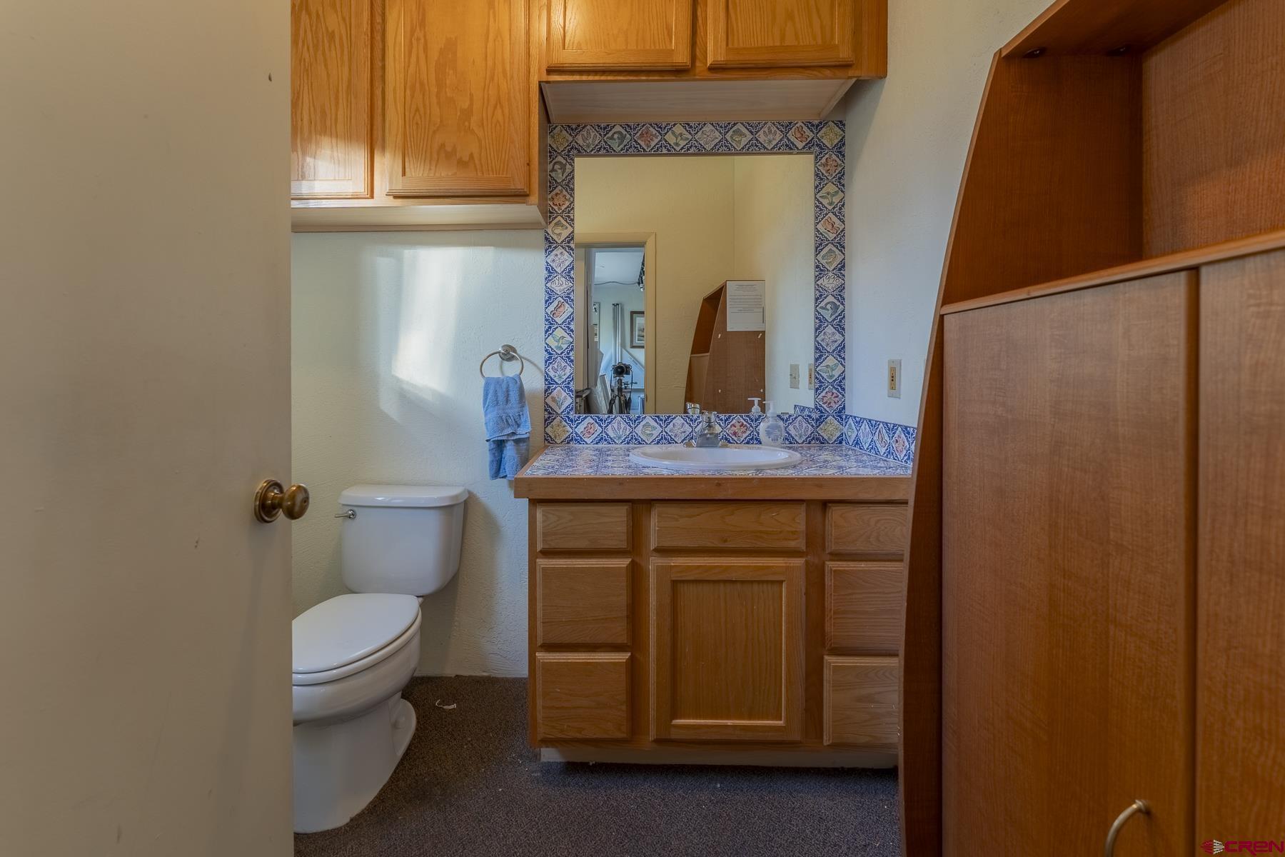 310 2nd Street Crested Butte, CO 81224 - Photo 35 of 42 a bathroom with a granite countertop sink toilet and mirror