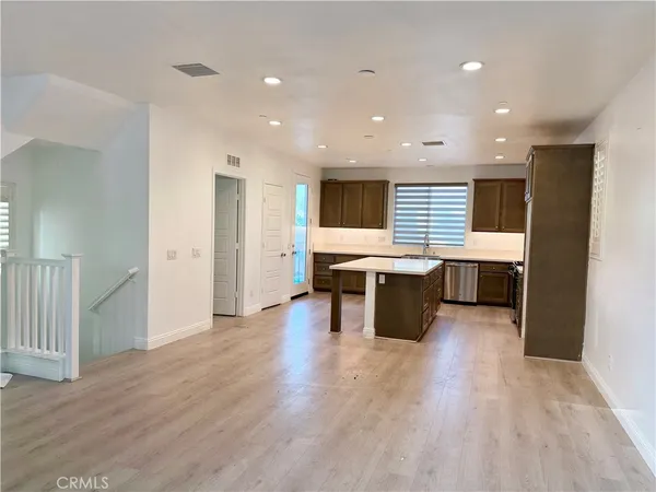 a view of kitchen with stainless steel appliances kitchen island wooden floor and chandelier