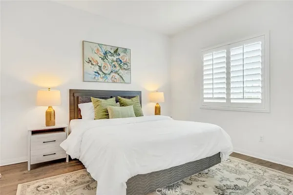 a bedroom with a bed and painting on the wall