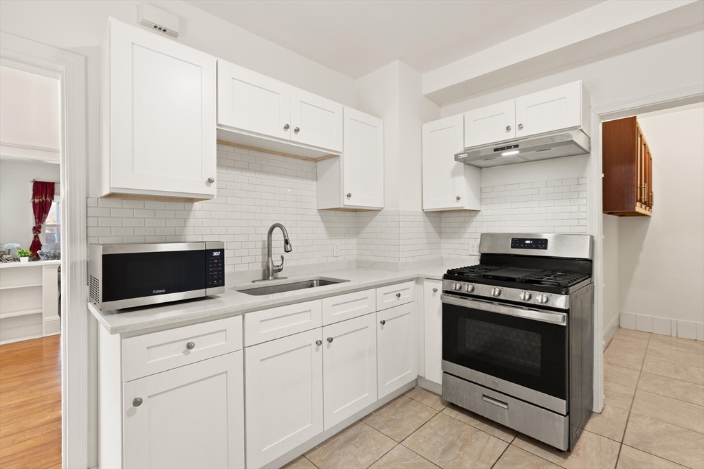 10 Minthorne Street Worcester, MA 01603 - Photo 16 of 29 a kitchen with white cabinets and appliances