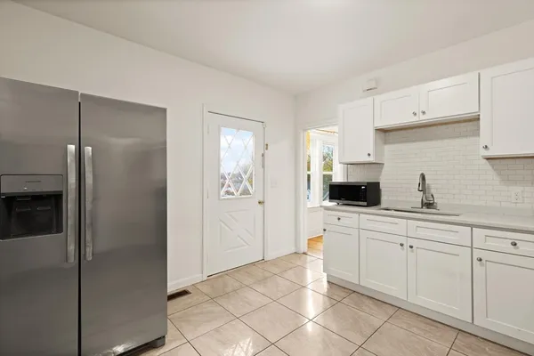 a kitchen with white cabinets and appliances