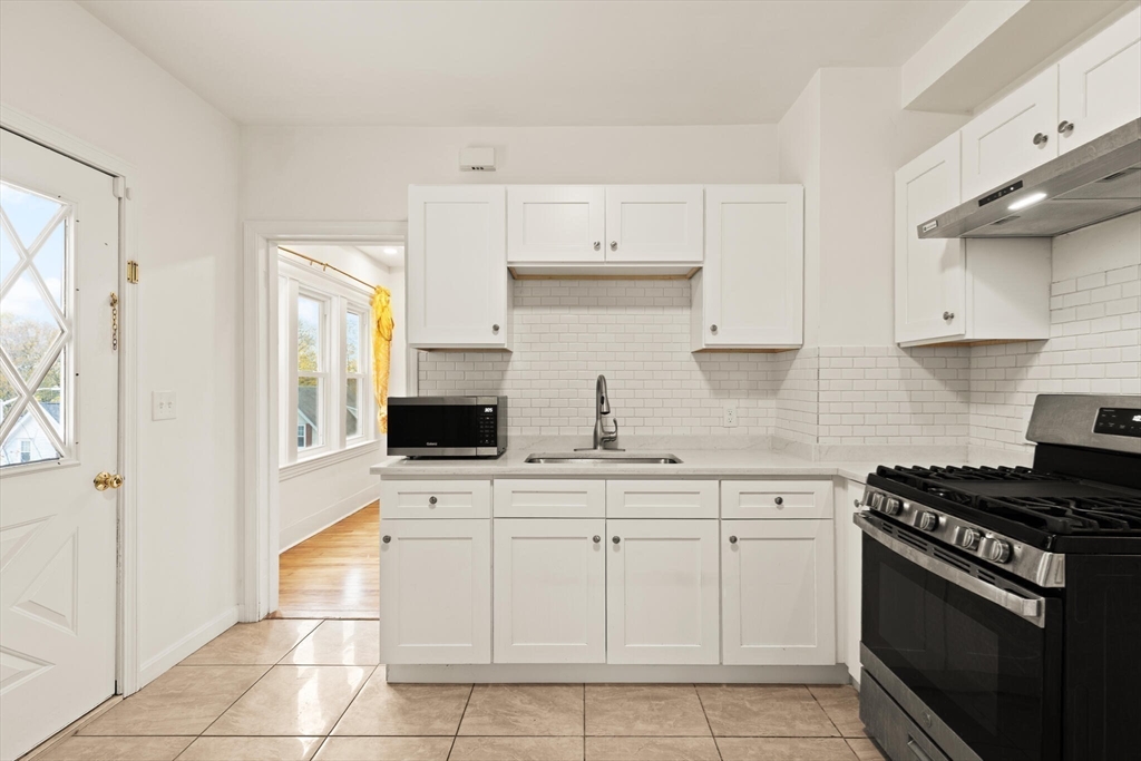 10 Minthorne Street Worcester, MA 01603 - Photo 18 of 29 a kitchen with white cabinets and appliances