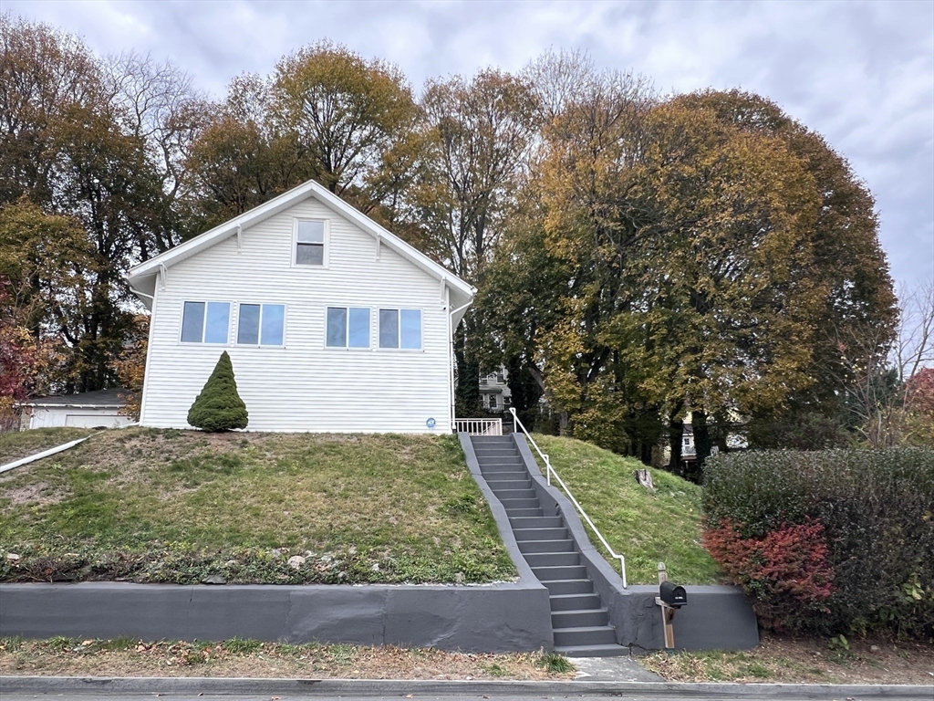 10 Minthorne Street Worcester, MA 01603 - Photo 28 of 29 a view of a white house next to a yard with plants and trees