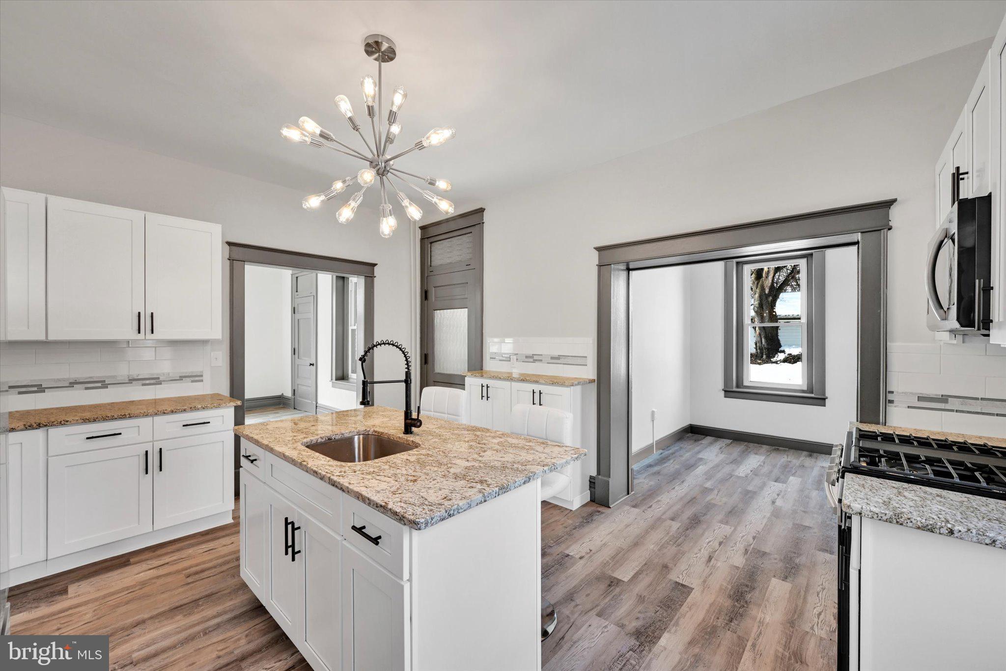 32 North Main Street Topton, PA 19562 - Photo 14 of 36 a kitchen with granite countertop a stove cabinets and wooden floor