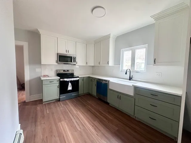 a kitchen with a sink a counter top space stainless steel appliances and a window