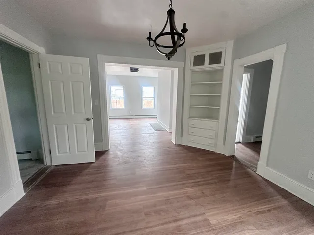 a view of a hallway with wooden floor and closet area