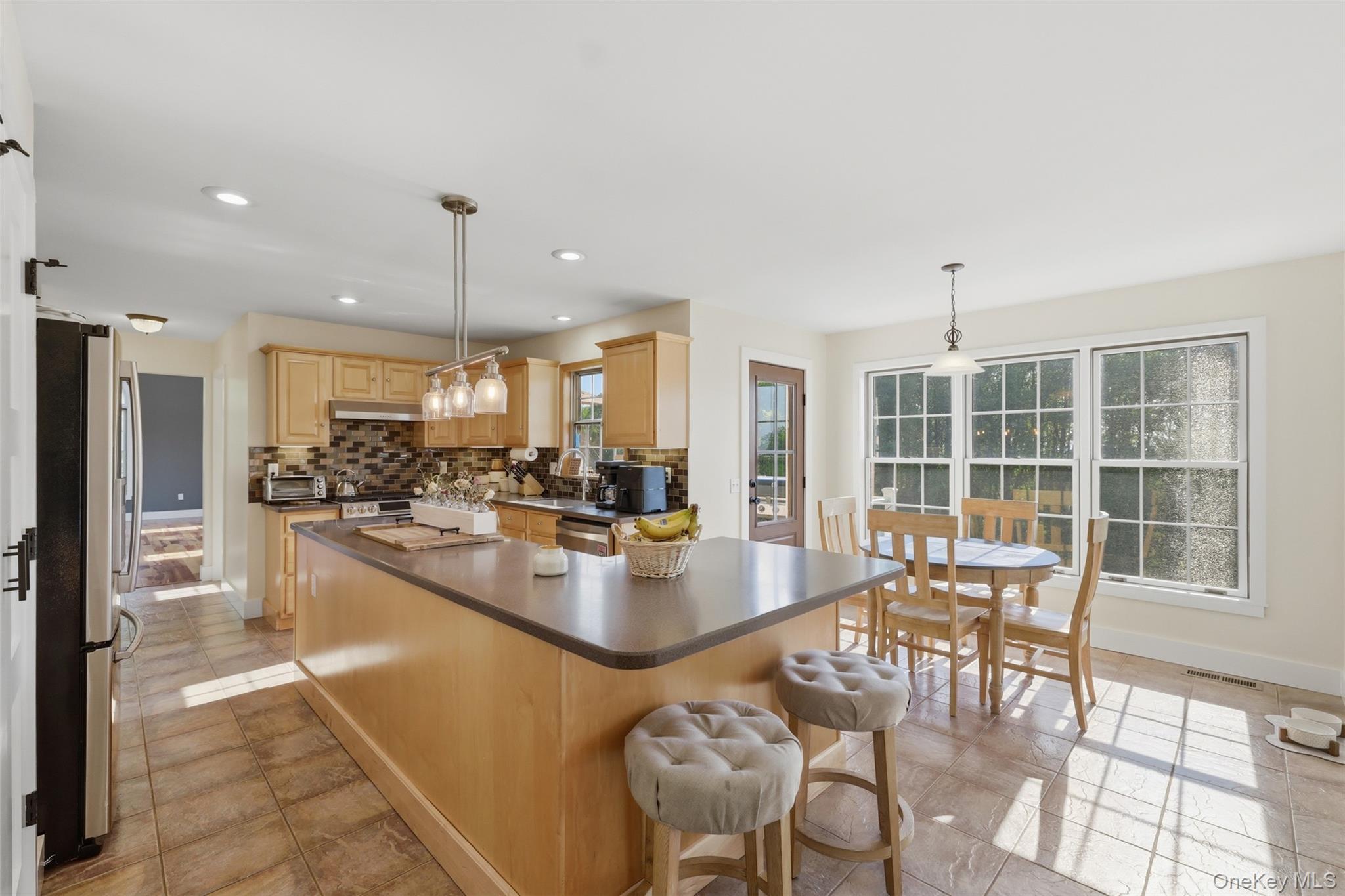 233 Devon Farms Road Stormville, NY 12582 - Photo 16 of 48 a dining hall with stainless steel appliances granite countertop a stove and a dining table with the view of kitchen