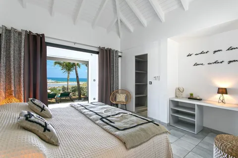 a bedroom with a bed a large window and walk in closet