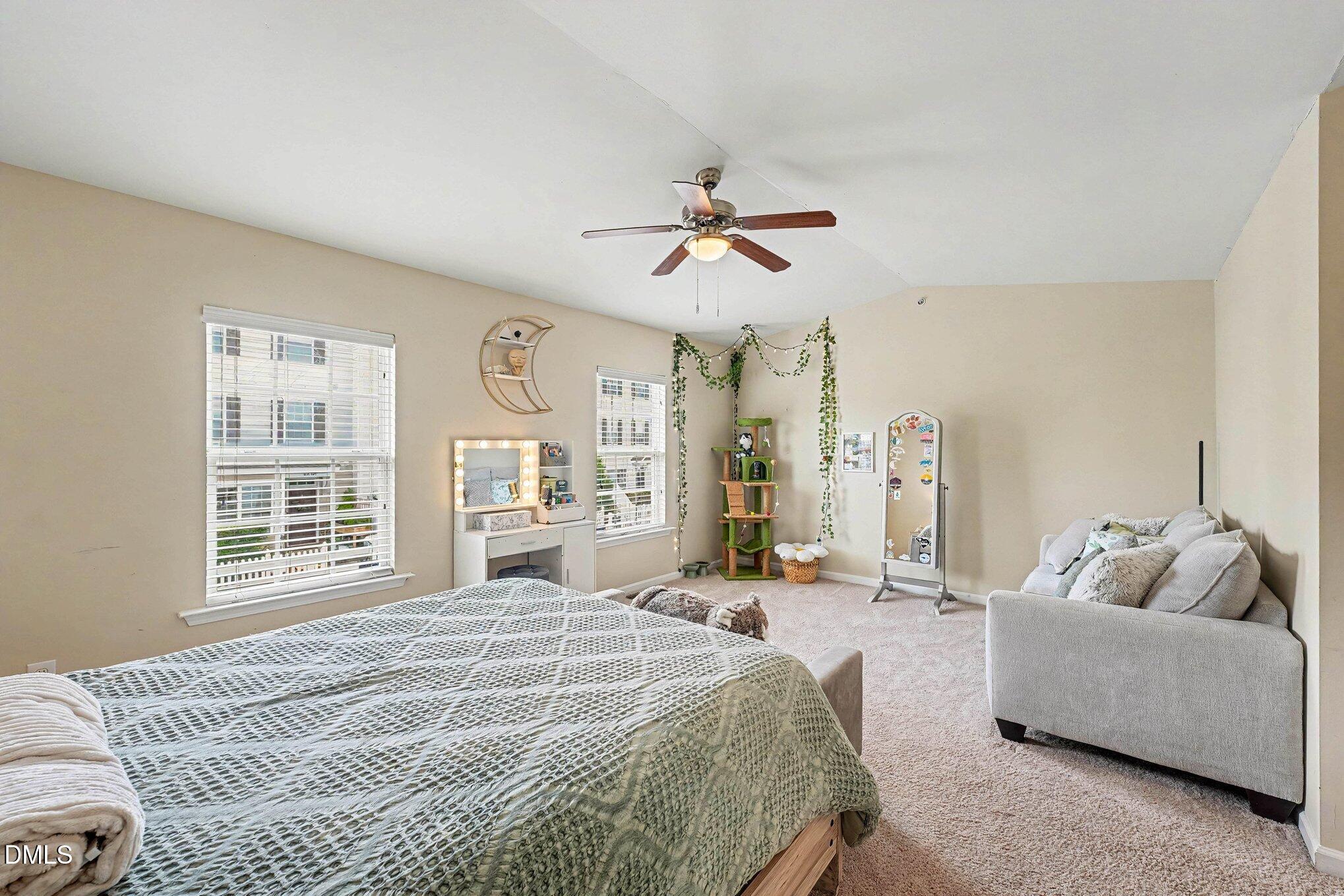 1130 Renewal Place, Unit 106 Raleigh, NC 27603 - Photo 14 of 34 a spacious bedroom with a bed a couch and a window