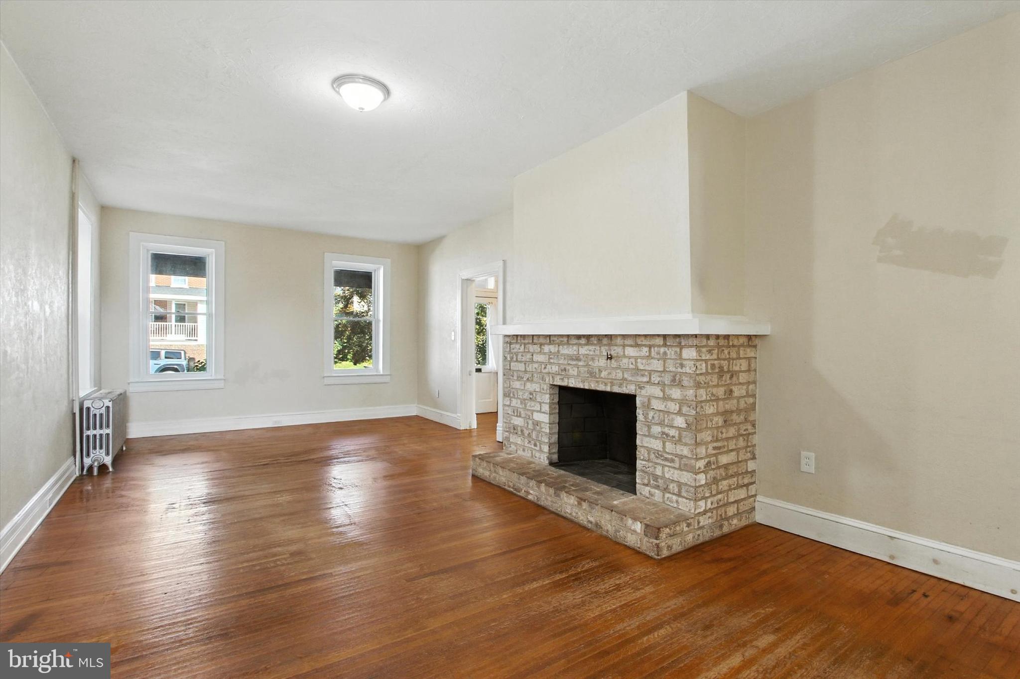 46 North Main Street Spring Grove, PA 17362 - Photo 2 of 25 an empty room with wooden floor fireplace and windows
