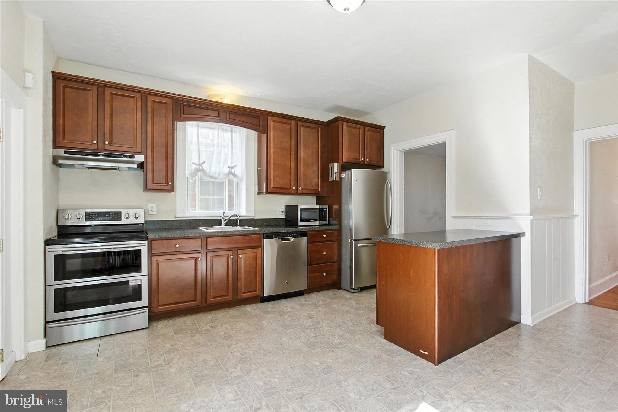 46 North Main Street Spring Grove, PA 17362 - Photo 5 of 25 a kitchen with granite countertop a refrigerator stove top oven and sink