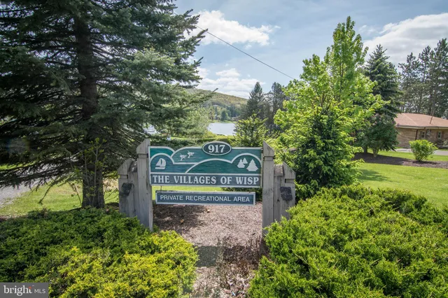 a backyard of a house with table and chairs and a large tree