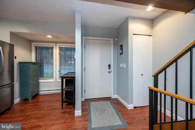 a view of a hallway with wooden floor and cabinets