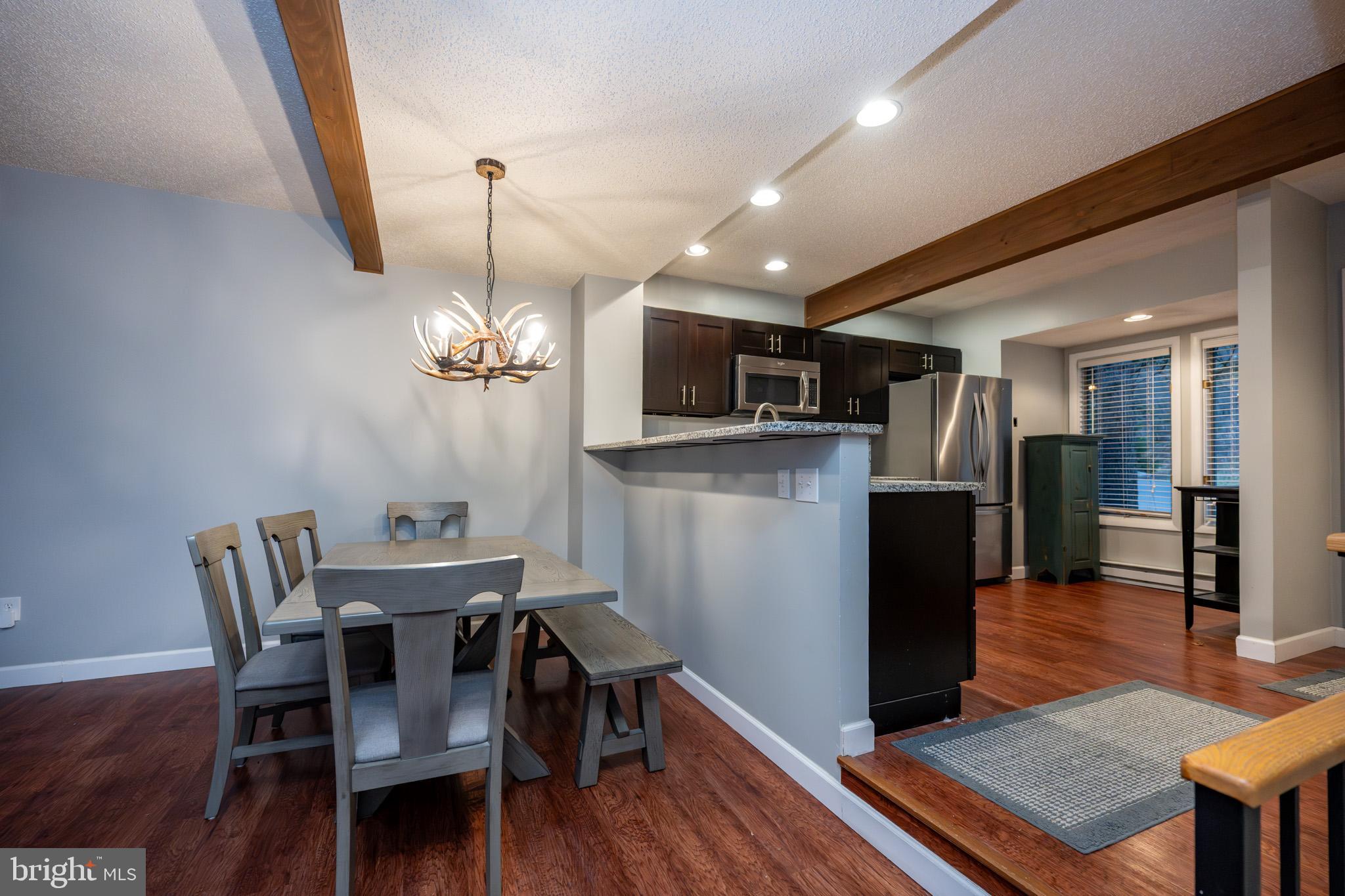 48 Bright Passage, Unit 5B McHenry, MD 21541 - Photo 7 of 56 a view of a dining room with furniture wooden floor and chandelier