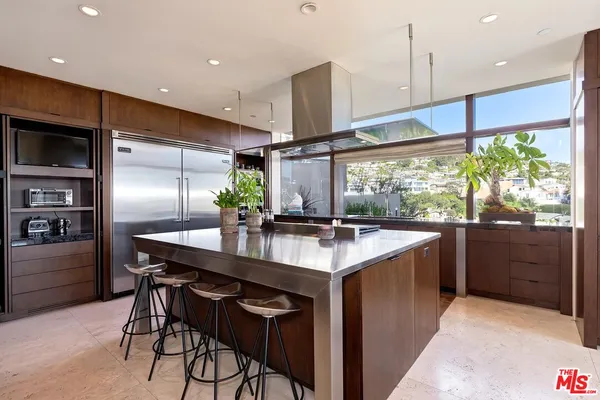 a kitchen with stainless steel appliances granite countertop a sink a stove and a refrigerator