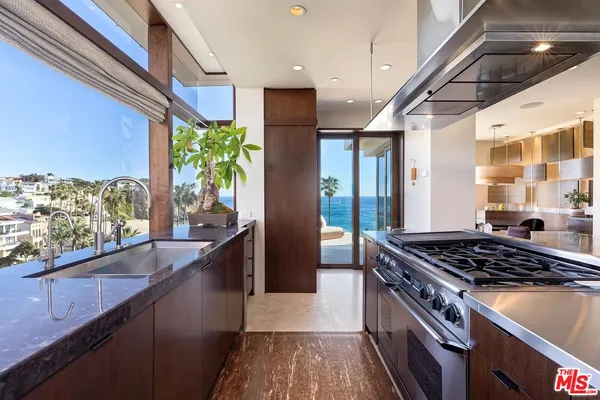 a kitchen with stainless steel appliances granite countertop a stove a sink and a refrigerator