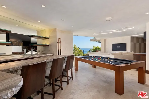 a kitchen with stainless steel appliances granite countertop table chairs sink and window