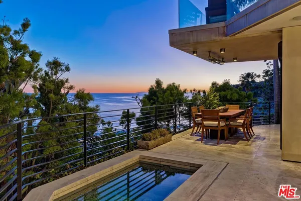 a view of a roof deck with table and chairs