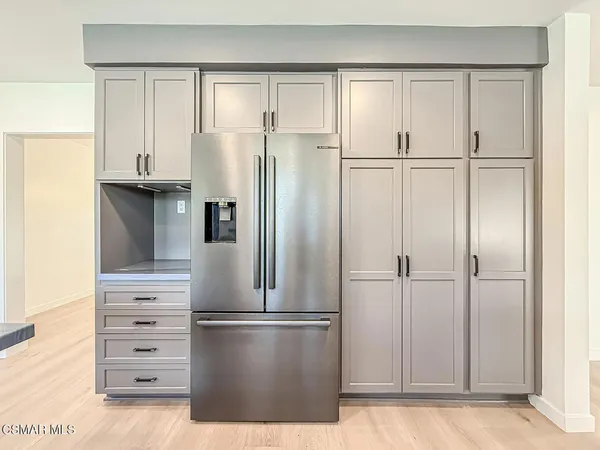 a kitchen with stainless steel appliances granite countertop a stove top oven a sink dishwasher a dining table and chairs with wooden floor