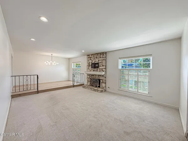 an empty room with furniture and large windows