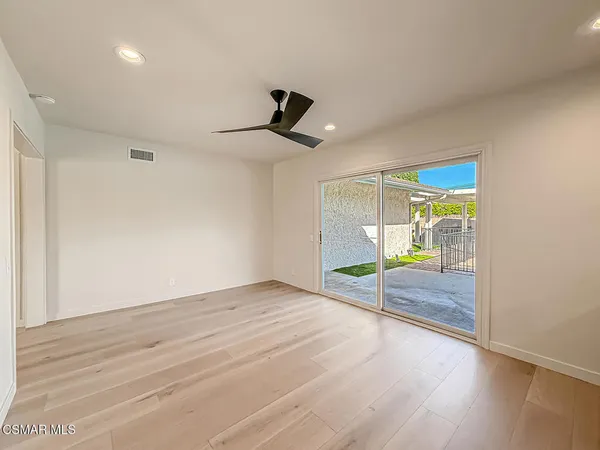 a living room with furniture kitchen view and a large window