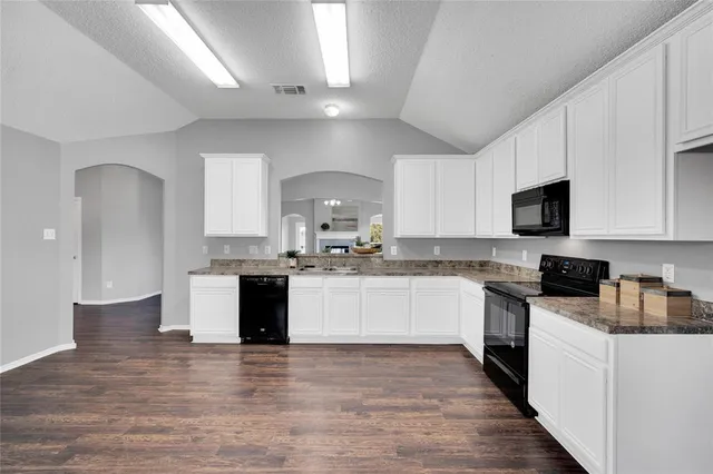a kitchen with a sink cabinets and wooden floor