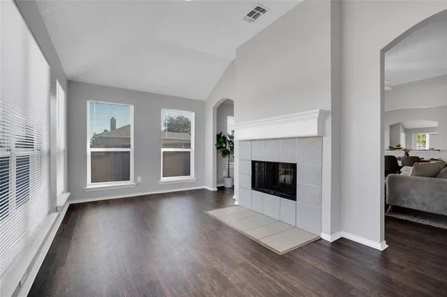 a view of a livingroom with wooden floor and a fireplace