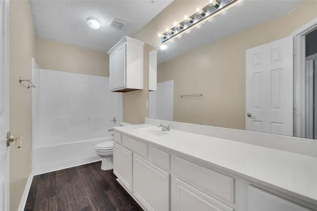 a bathroom with a sink a toilet a mirror and shower