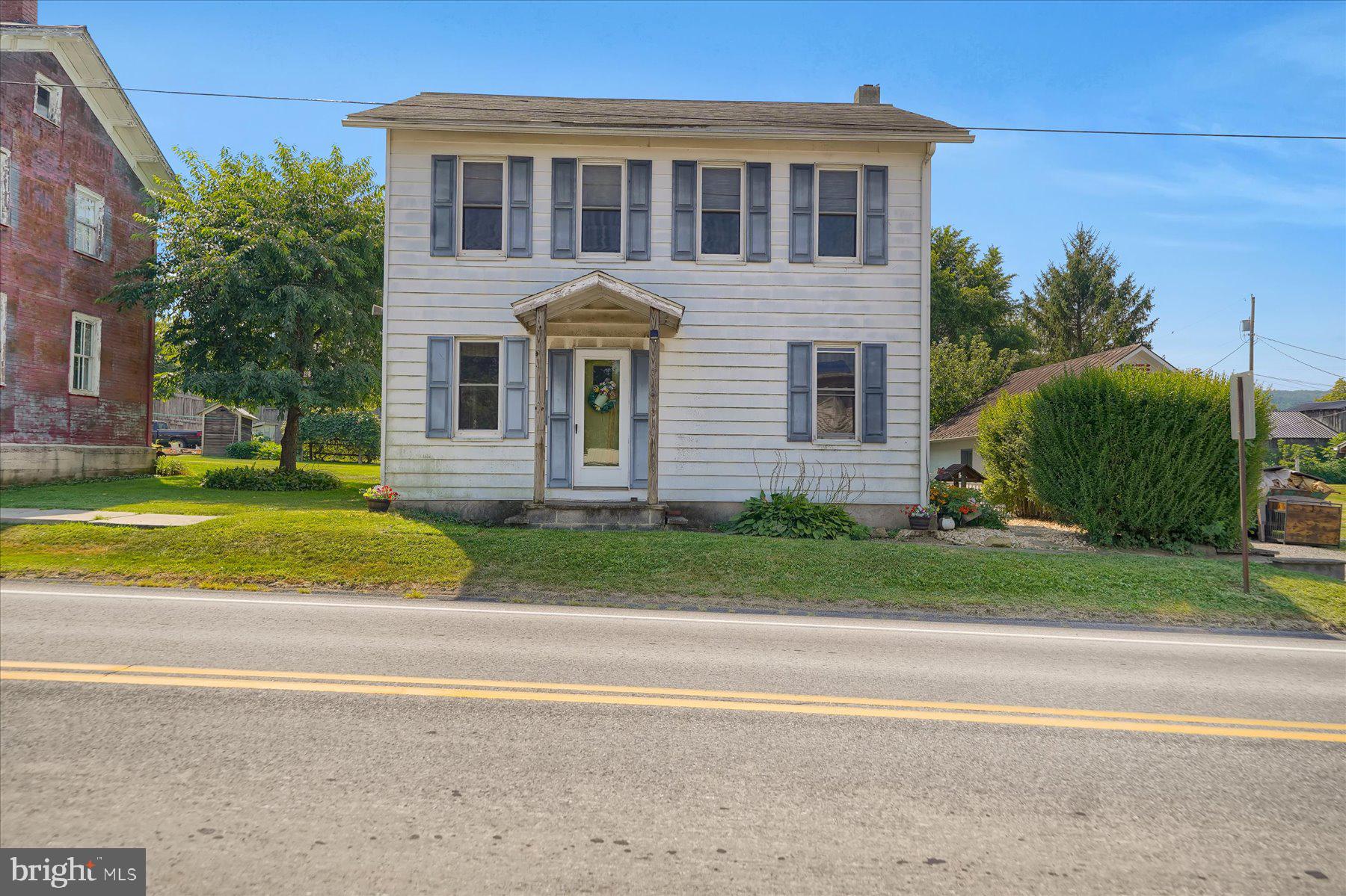 a front view of a house with a yard and trees