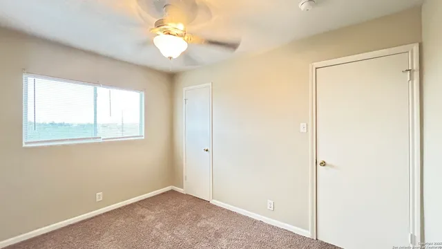 an empty room with a ceiling fan and a fan