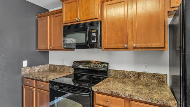 a kitchen with granite countertop wood cabinets and a stove top oven
