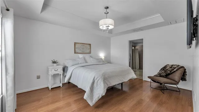 a bedroom with a bed and wooden floor