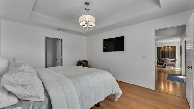 a bedroom with a bed and a chandelier