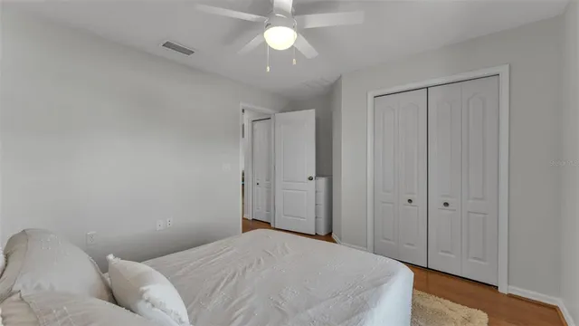 a bedroom with a bed and a chandelier fan