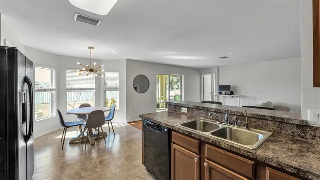 a kitchen that has a sink a table and chairs in it