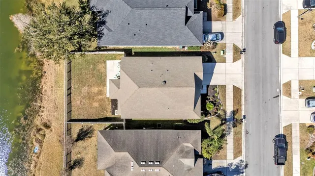 an aerial view of a house with a yard and large tree