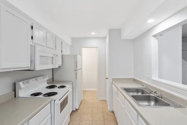 a kitchen that has a sink a stove and a refrigerator