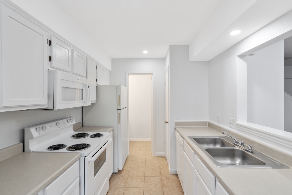 8703 Schick Road, Unit A Austin, TX 78729 - Photo 4 of 21 a kitchen that has a sink a stove and a refrigerator